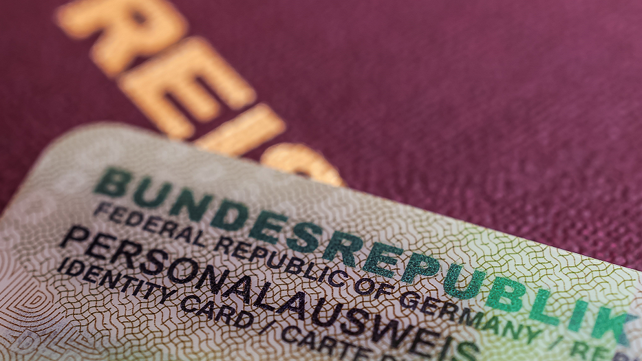 Das Foto zeigt den Personalausweis und den darunter liegenden Reisepass in Nahaufnahme.